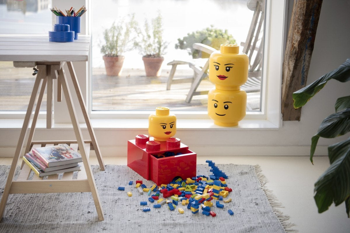 Pojemniki LEGO głowa dziewczynka w kolorze żółtym do przechowywania klocków na dywanie w pokoju dziecięcym