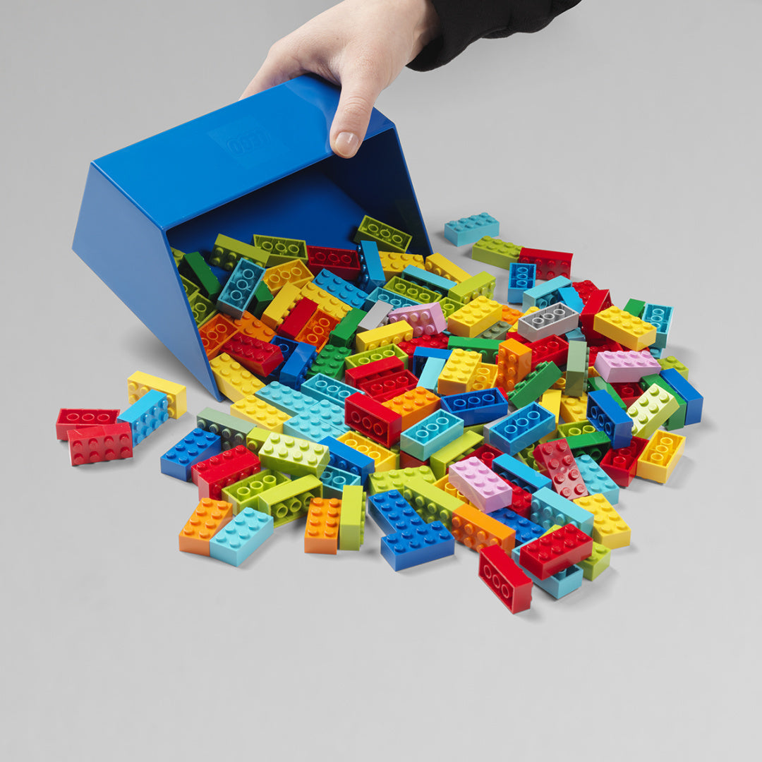 Ręka trzyma niebieską szufelkę z rozsypanymi kolorowymi klockami zestaw szufelek LEGO