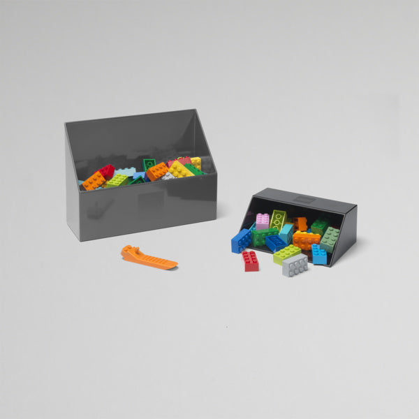 Czarna szufelka do klocków LEGO z kolorowymi klockami i pojemnikami na białym tle