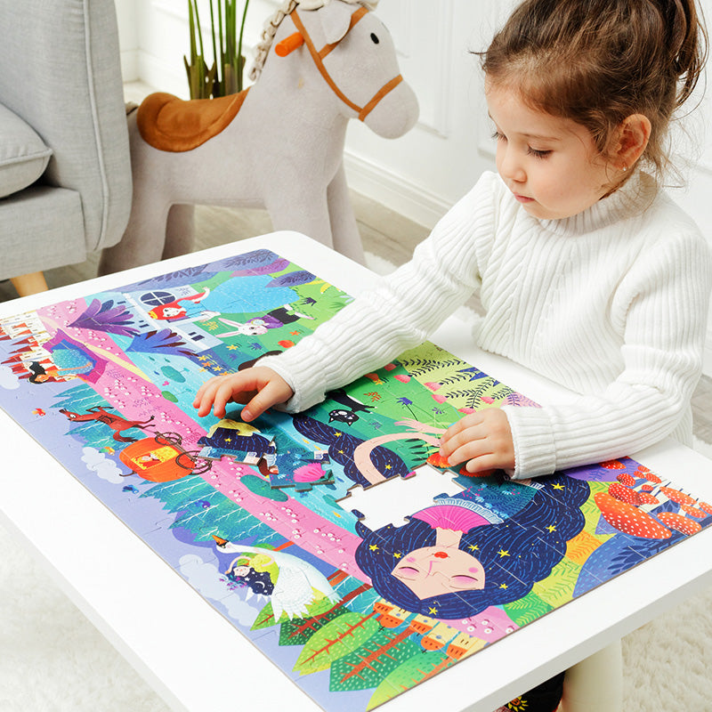 Dziecko układa kolorowe puzzle Śpiąca Królewna dla dzieci marki mideer na białym stole