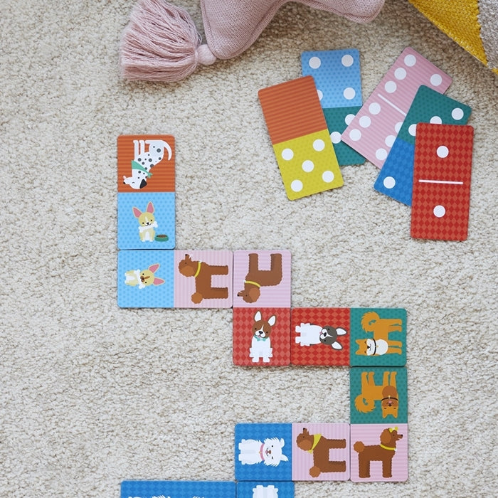 Kolorowe domino z pieskami dla dzieci na jasnym dywanie z różowymi i żółtymi poduszkami